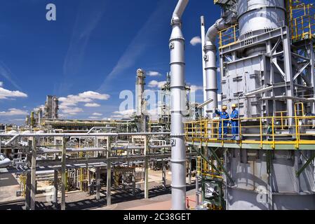 Gruppe von Industriearbeitern in einer Raffinerie - Öl verarbeitende Ausrüstung und Maschinen Stockfoto