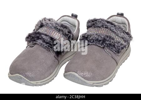 Kind Schuhe Mode. In der Nähe von ein paar schöne Grau Silber wildleder Sneaker oder sportliche Schuhe für Mädchen mit Fell und Strass Dekoration isoliert auf einem Stockfoto