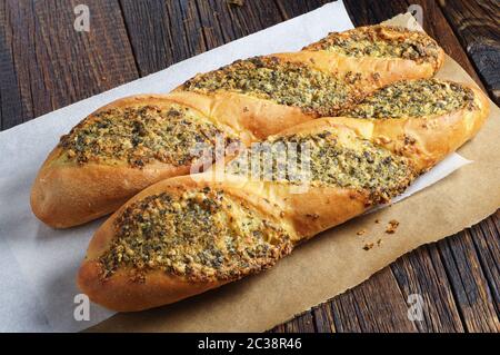 Zwei kleine Baguettes gefüllt mit Gewürzen auf altem Holztisch Stockfoto