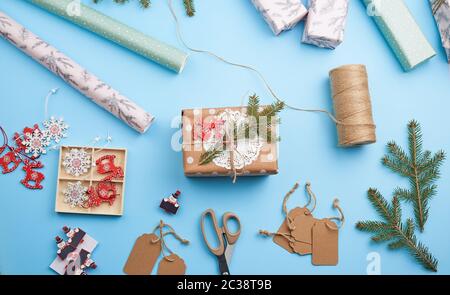 Rolle von rosa Geschenkpapier, Dekor, Zweige Fichte, Weihnachten Spielzeug und Kartons mit Geschenken auf blauem Hintergrund, Ansicht von oben. Weihnachten Konzept Stockfoto
