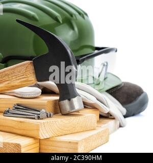 Nahaufnahme eines Zimmermanns hammer, Helm, Schutzbrille und Schutzhandschuhe auf einem weißen Hintergrund. Industrie Bau, Arbeitssicherheit. Stockfoto