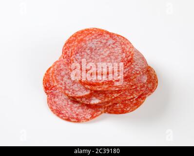 Dünn geschnittene Salami Wurst auf weißem Hintergrund Stockfoto