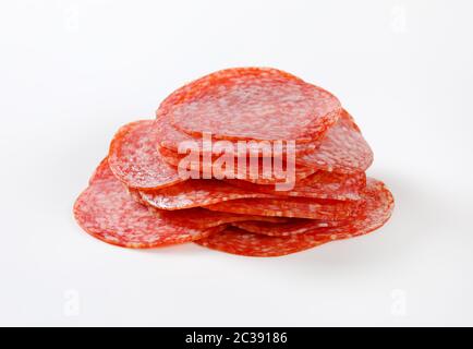 Dünn geschnittene Salami Wurst auf weißem Hintergrund Stockfoto