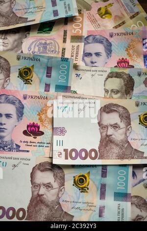 Ukrainisches Geldmuster aus neuer Banknote. Papier hryvnias verschiedenen Nennwert mit 1000 hryvnias auf der Oberseite. Hintergrund oder Textur. Vertikales Format Stockfoto
