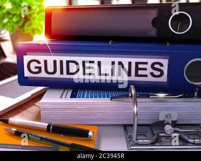 Blauer Ringordner mit Beschriftung Richtlinien auf dem Hintergrund des Arbeitstisch mit Bürobedarf und Laptop. Richtlinien Geschäftskonzept auf verschwommene Ba Stockfoto