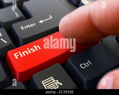 Der Computerbenutzer drückt die rote Taste Fertig stellen auf der schwarzen Tastatur. Nahaufnahme. Verschwommener Hintergrund. 3D-Rendern. Stockfoto