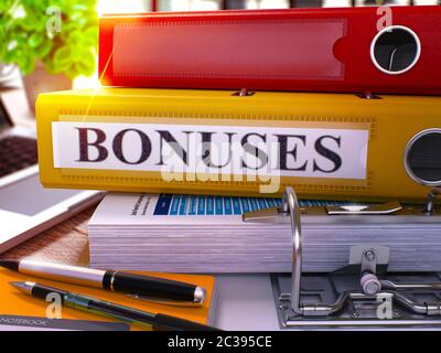 Gelbe Ringordner mit Inschrift Boni auf dem Hintergrund der Arbeitstisch mit Bürobedarf und Laptop. Boni - Getönte Illustration. Boni Busi Stockfoto