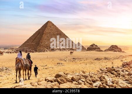 Die Pyramide des Menkaure und Touristen auf Kamelen, Giza, Ägypten. Stockfoto