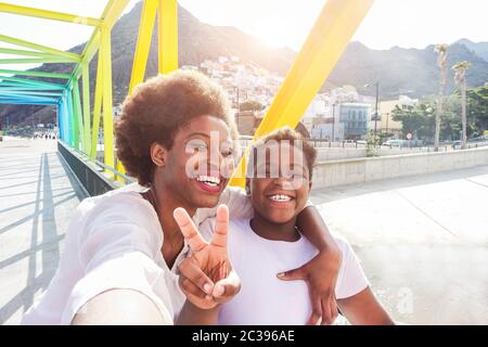 Fröhliche junge Mutter, die im Sommer sonnig mit ihrem Kind Spaß hat - Son nimmt selfie mit seiner Mutter im Freien - Familienleben, Mutterschaft, Liebe und tec Stockfoto