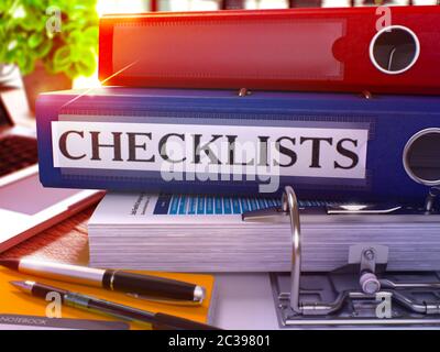 Blauer Ringordner mit Beschriftung Checklisten auf dem Hintergrund des Arbeitstisches mit Bürobedarf und Laptop. Checklisten Business Concept auf Blurred Ba Stockfoto