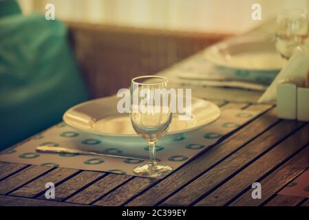 Leere geschirr Tisch im Restaurant mit Glas und Platte, Sommer romantischen Stil in blau und braun Farben Stockfoto