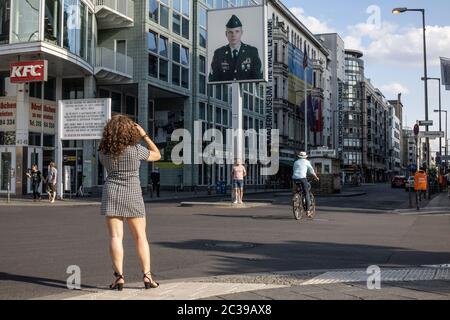 Eine Frau fotografiert am Checkpoint Charlie in der Friedrichstraße, dem Grenzübergang zwischen Ost-Berlin und West-Berlin im Kalten Krieg. Stockfoto