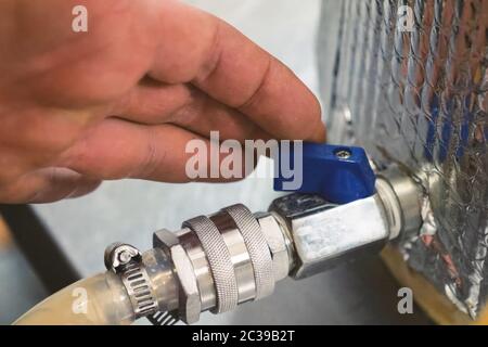 Installation des Krans auf einem Tank mit Flüssigkeit. Kugelhahn- und Rohradapter. Stockfoto