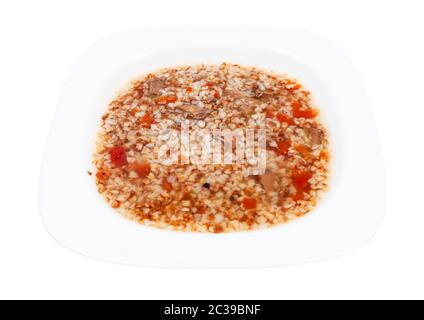 Fleischsuppe mit Buchweizen in weißem Suppenteller isoliert auf weißem Hintergrund Stockfoto