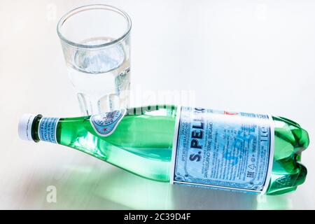 MOSKAU, RUSSLAND - 16. JUNI 2020: Liegende Flasche S Pellegrino und Glas mit Wasser auf dem Tisch. S.Pellegrino ist ein natürliches Mineralwasser aus San Stockfoto