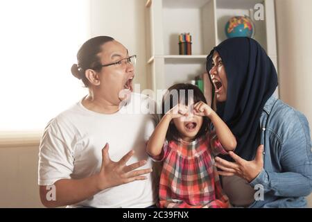 Frustriert kleines Mädchen Tochter Angst mit Mama und Papa zu Hause kämpfen, Asian muslimische Eltern Konflikt schreien einander macht ihr Baby weint, d Stockfoto