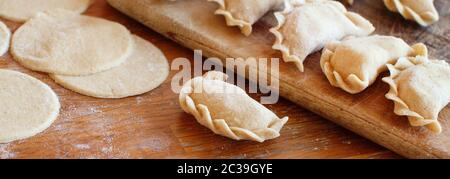 Rohes Fleisch die Maultaschen, Ravioli, Knödel auf einem Holzbrett Stockfoto