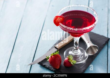 Erdbeer Cocktail Drink in Glas auf blauem Holztisch Stockfoto