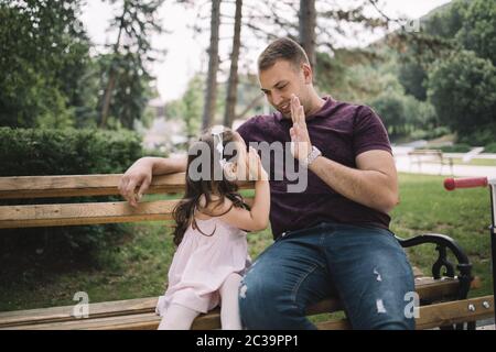 Vater und Tochter geben hohe fünf im Park Stockfoto