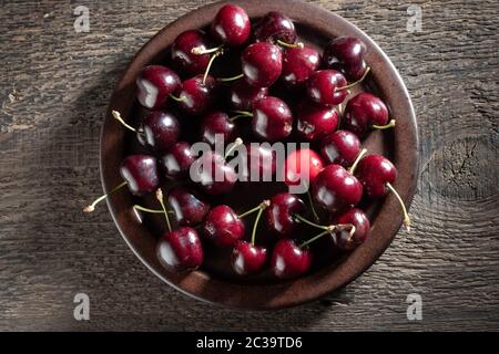 Frische Kirschen mit Wassertropfen auf einem Teller, Draufsicht Stockfoto