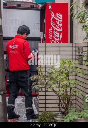 Mann, der Coca Cola-Getränke in Nakameguro, Tokio, Japan, liefert und auffüllt Stockfoto