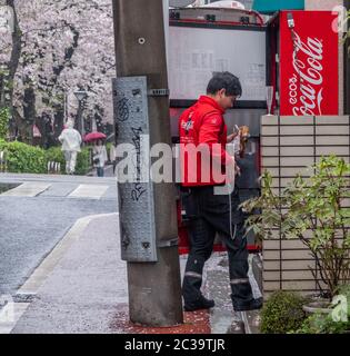 Mann, der Coca Cola-Getränke in Nakameguro, Tokio, Japan, liefert und auffüllt Stockfoto