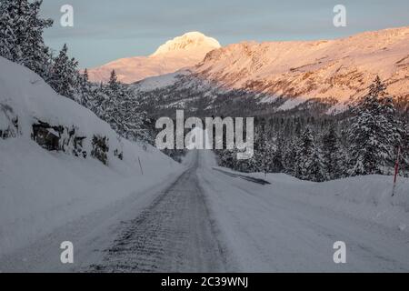 Eine gefrorene Straße schlängelt sich durch den Norden Norwegens. Stockfoto