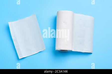 Rolle weißen Papierhandtuch auf blauem Hintergrund. Blatt Papier. Hausrat. Weisse Serviette. Stockfoto