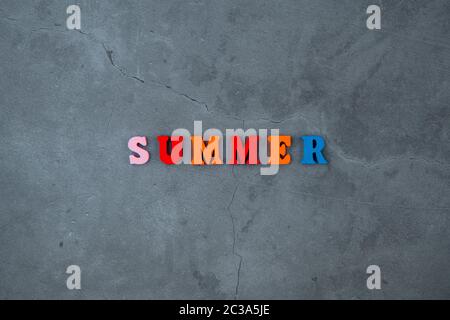 Die bunten Sommer Wort ist aus Holz Buchstaben auf einem grau verputzte Wand Hintergrund gemacht Stockfoto