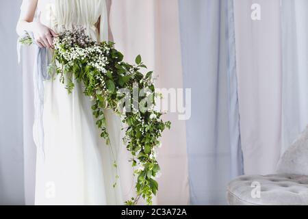 Braut in zartem Kleid mit unusial Bouquet von kleinen weißen Blumen Stockfoto