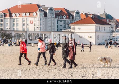 Im Winter laufen die Menschen am Sandstrand. Perfekter Winterurlaub. Die Leute entspannen sich in der kalten Jahreszeit an der Küste. Danzig, Polen Februar Stockfoto