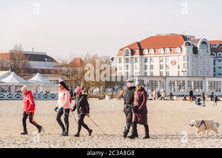 Polen, Sopot, 9. Februar 2020. Leute joggen am Strand. Nordic Walking. Wintersaison am Meer. Winterspaziergang am Strand. Menschen Stockfoto