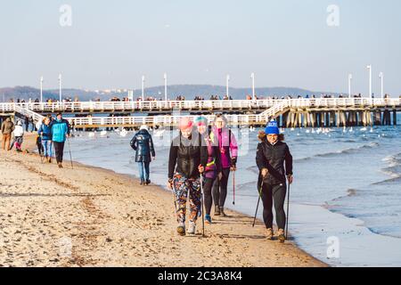 Polen, Sopot, 9. Februar 2020. Menschen am Strand in Sopot. Menge am Strand im Winter. Genießen Sie den Tag im sonnigen Winter in der Nähe des Meeres. Stockfoto