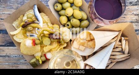 Tapas und Pinchos, Panorama. Käse, Jamon und Oliven, gildas und Kartoffelchips, mit Gläsern Rot- und Weißwein, On Stockfoto