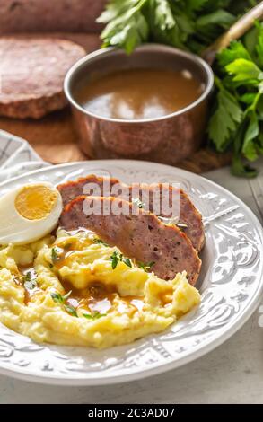 Hausgemachter Hackbraten mit Kartoffelpüree, Eiersauce und Kräutern Stockfoto