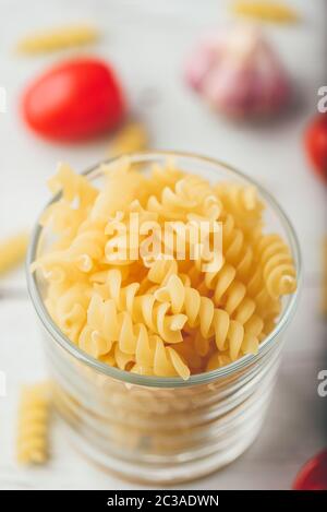 Italienische Fusilli in Glasschale mit Cherry Tomaten und Knoblauch Stockfoto