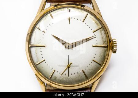 Eine alte mechanische Armbanduhr aus Gold mit Handaufzug. Antike Uhr ruiniert durch die Zeit, mit Kratzern und Mehltau Flecken, Rost, Oxidation. Lederriemen Stockfoto