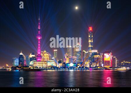 Lasershow über der beleuchteten Lujiazui Skyline und dem Huangpu Fluss bei Nacht, Shanghai, China Stockfoto