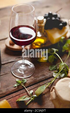 Glas Rotwein mit Käse und Trauben Stockfoto