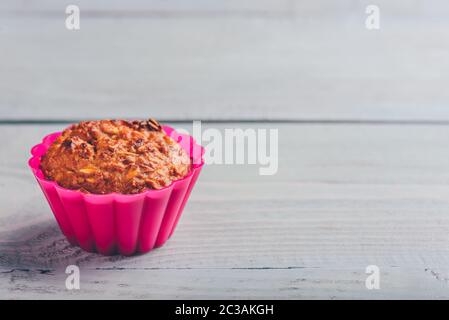Gekochte Haferflocken Muffin in einem rosa Silikon Backformen über hellen Hintergrund. Stockfoto