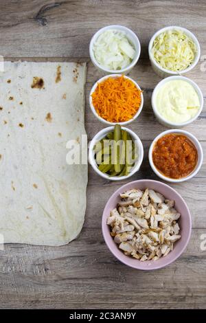 Vorbereitung für die Herstellung von Chicken Shawarma mit Zutaten, Huhn, Adjika, Gurken eingelegter, Shawarma-Sauce, koreanische Karotten, Kohl und Stockfoto