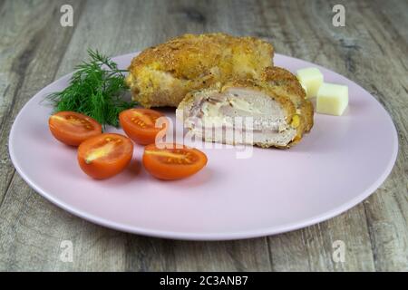 Hühnerrolle gefüllt mit Spinat und getrockneten Tomaten auf dem Holztisch Stockfoto