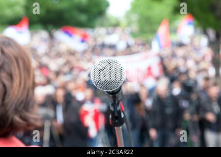 Protestieren. Öffentliche Demonstration. Mikrofon im Fokus gegen verwackelte Publikum. Stockfoto