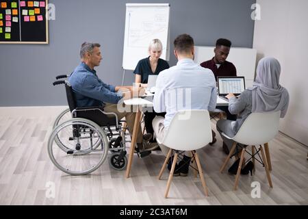 Deaktiviert Reife Geschäftsmann am Schreibtisch mit Laptop im Konferenzraum Stockfoto