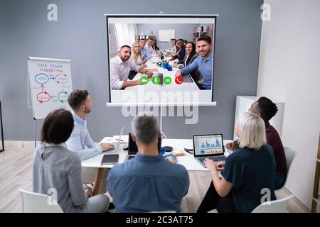 Gruppe von Geschäftsleuten mit Video-Konferenz im Sitzungssaal Stockfoto