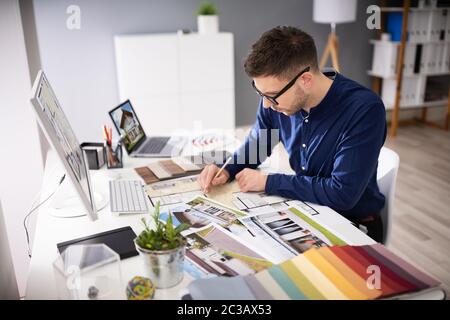 Seitenansicht von Immobilien Designer Arbeiten am Computer im Büro Stockfoto