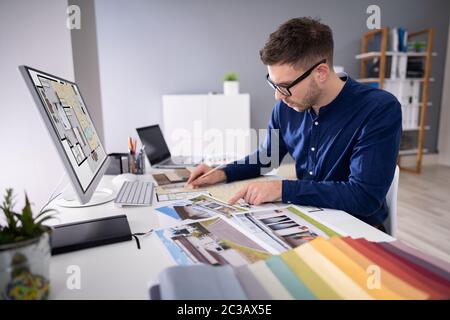 Seitenansicht von Immobilien Designer Arbeiten am Computer im Büro Stockfoto