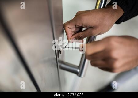 Reife männliche Lockpicker Festsetzung Türgriff zu Hause Stockfoto