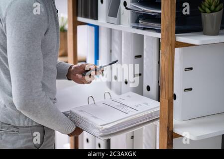 Nahaufnahme der Hand, denn ein Geschäftsmann Foto von Bill mit Handy Stockfoto