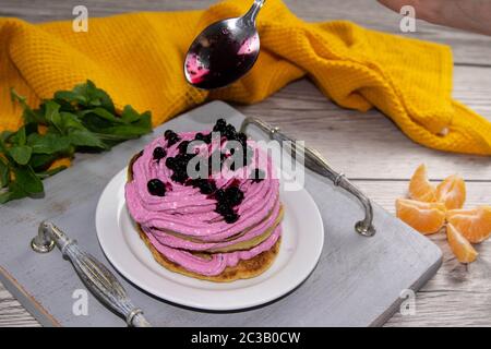 Pfannkuchen schütteten Sahne mit Hüttenkäse und Blaubeeren auf einer schönen Holzschale, neben Blaubeere Marmelade und Minze, schöner Hintergrund, Top-Ansichten Stockfoto